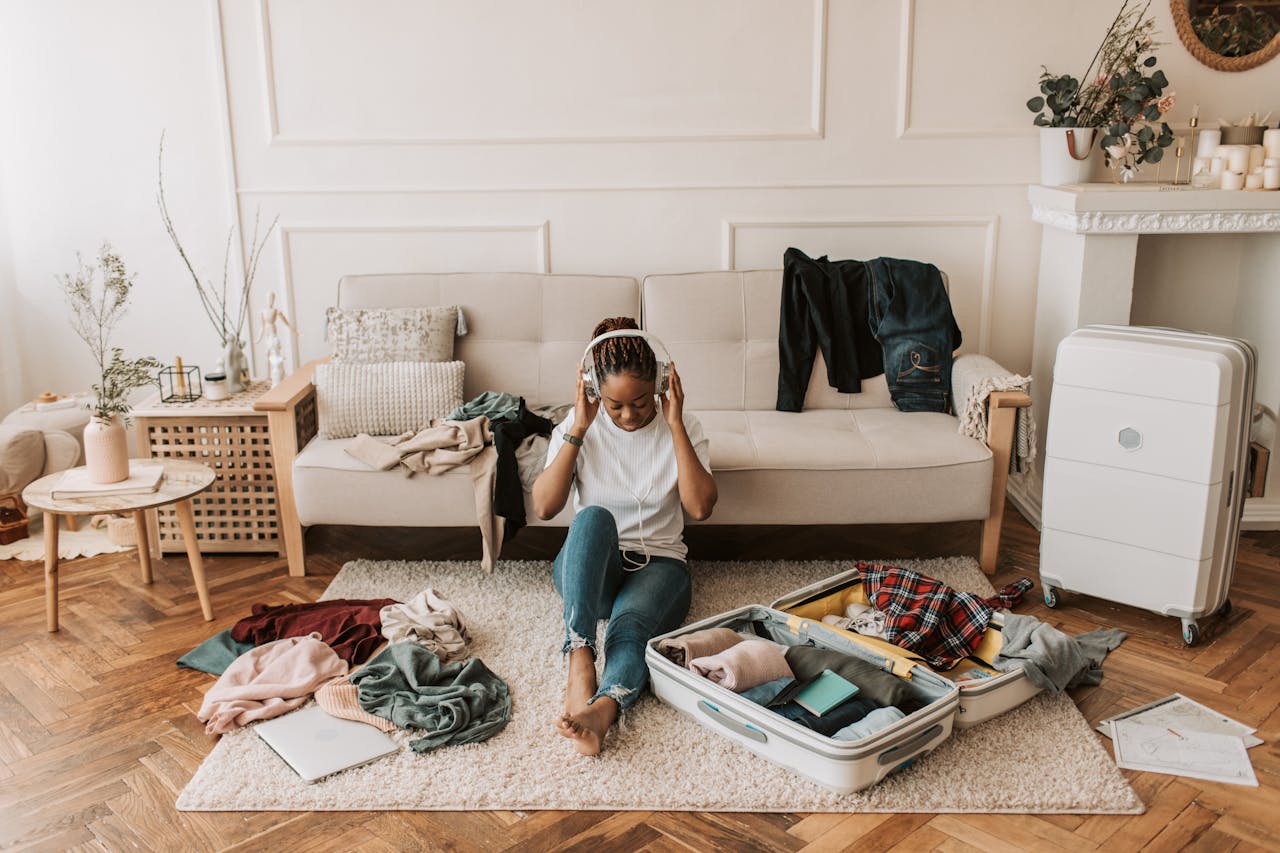 Women in Headphone Packing Luggage In House